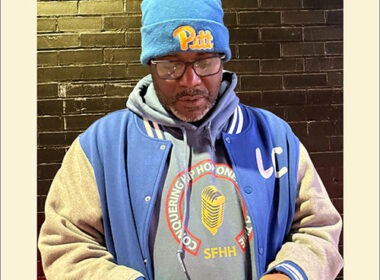 Hip-Hop artist J. Sands wearing the Conquering Hip-Hop One Mic At A Time hoodie in an urban setting, representing SpitFireHipHop culture.