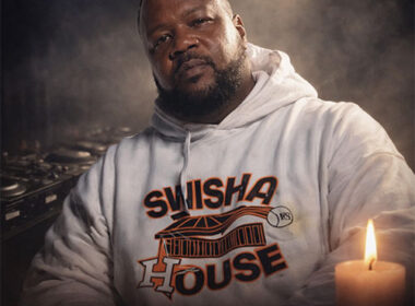 Photorealistic memorial tribute of DJ Michael “5000” Watts wearing a white Swishahouse hoodie, seated before DJ turntables with a candle glowing at his side, honoring the Houston hip-hop pioneer.