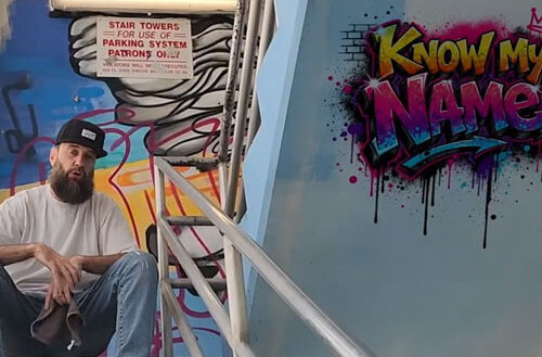 Travisty The Lazy Emcee sits beside colorful graffiti artwork in the “Know My Name” music video alongside visuals promoting the underground Hip-Hop single produced by DJ Kawon.