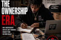 An independent artist sitting alone in a creative workspace reviewing contracts, notebooks, merchandise designs, and music release plans. Clean editorial composition, natural lighting, premium magazine feel, minimal typography, official SpitFireHipHop logo top-left, SFHH editorial badge bottom-right.