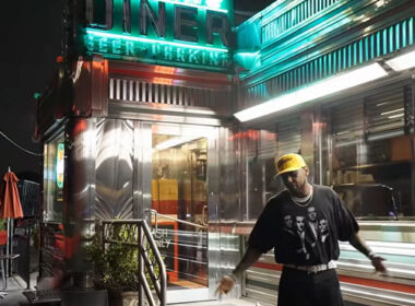 Fabolous outside a brightly lit diner at night in the “Lufthansa Heist Freestyle” music video.