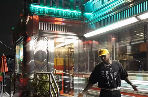 Fabolous outside a brightly lit diner at night in the “Lufthansa Heist Freestyle” music video.