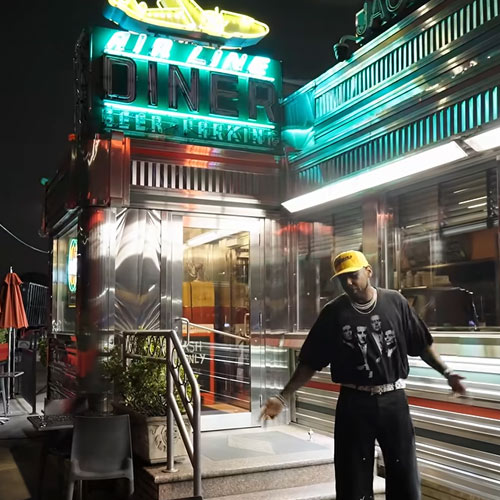 Fabolous outside a brightly lit diner at night in the “Lufthansa Heist Freestyle” music video.