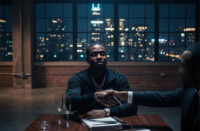 Independent Hip-Hop label executive reviews music distribution infrastructure and business reports in a dark professional studio for SpitFireHipHop's Corporate Corner feature, The New Middleman.